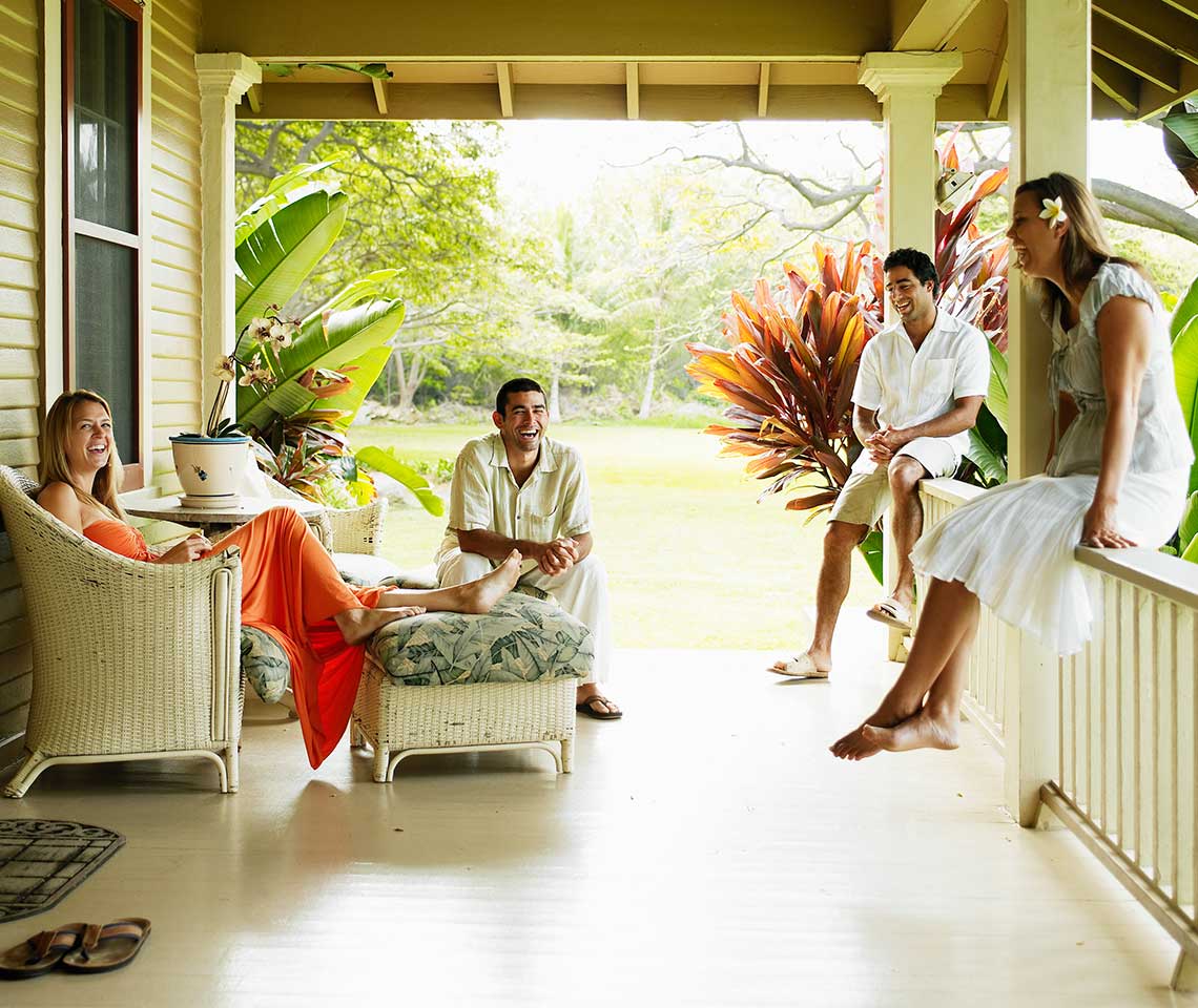 Four-people-laughing-on-a-porch-in-Hawaii